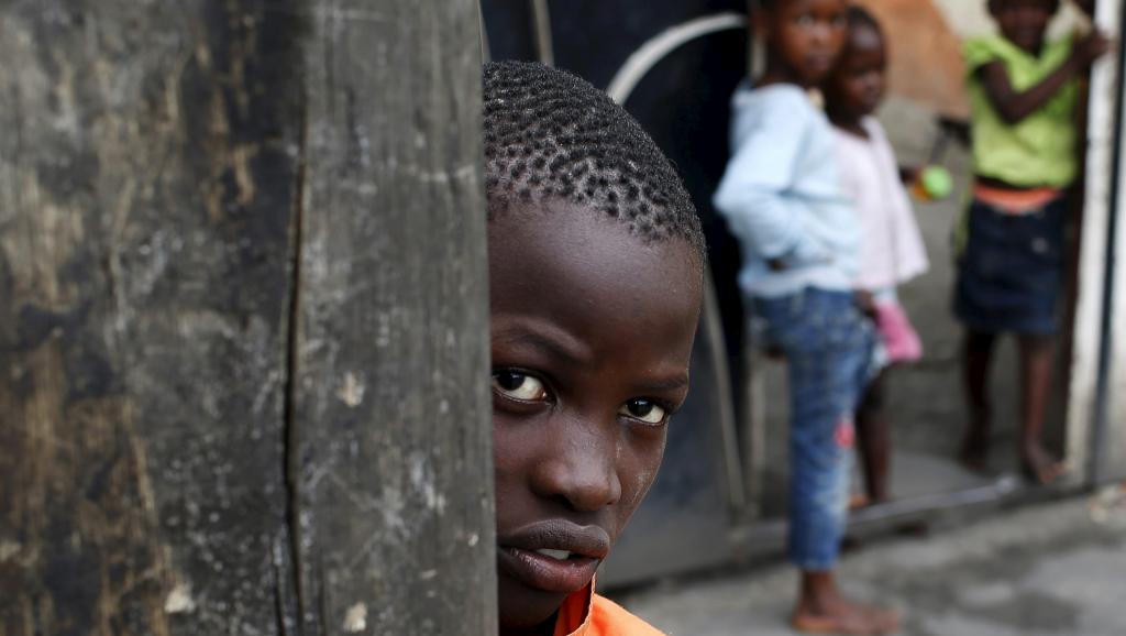 Un enfant regarde des policiers détruire une barricade dans les rues de Bujumbura, le 30 mai 2015. REUTERS/Goran Tomasevic