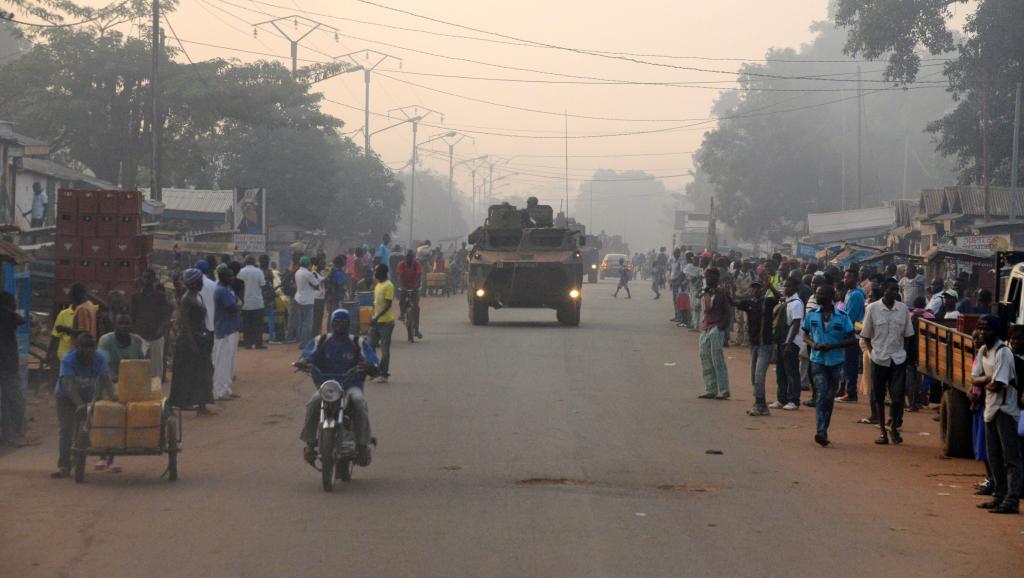Dans une rue de Bangui, un blindé de Sangaris patrouille au loin. AFP PHOTO / PACOME PABANDJI