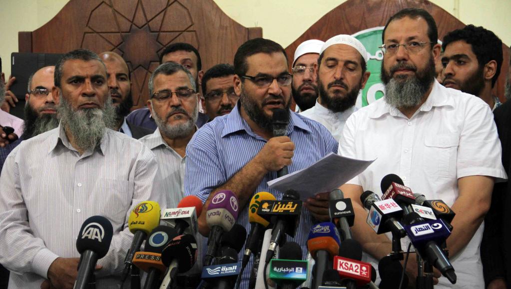 Des membres des Frères musulmans et Safwat Abdel Ghani (au centre), ex-membre des islamistes radicaux du groupe Gamaa Islamiya, lors d'une conférence de presse en marge des manifestations géantes qui ont mené à la chute de Mohamed Morsi en juillet 2013. AFP PHOTO / KHALED KAMEL