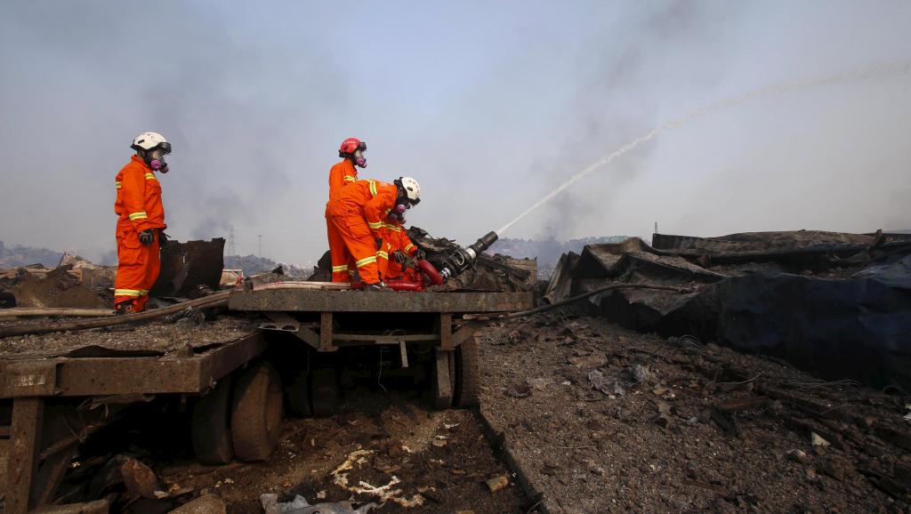 Les pompiers sont toujours en action ce samedi 15 août sur le site de la catastrophe industrielle, porteurs de masques à gaz en raison des émanations toxiques. REUTERS/China Daily