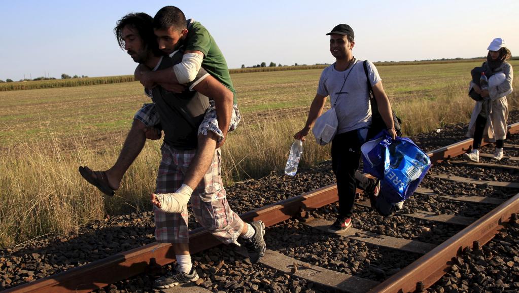 Une famille de migrants syriens à la frontière serbo-hongroise, près de Roszke, le 26 août 2015. REUTERS/Bernadett Szabo