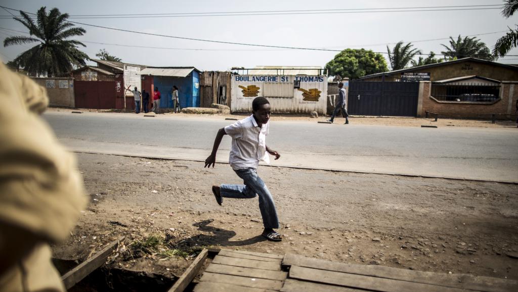 Un homme fuit les violences dans le quartier de Cibitoke, à Bujumbura, le 1er juillet 2015. AFP PHOTO / MARCO LONGARI