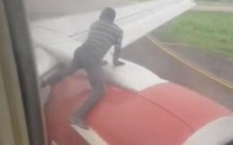 Un homme arrêté sur l'aile d'un avion peu avant le décollage