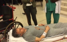 Photo: Bibo Bourgi couché sur un lit d’hôpital en plein procès